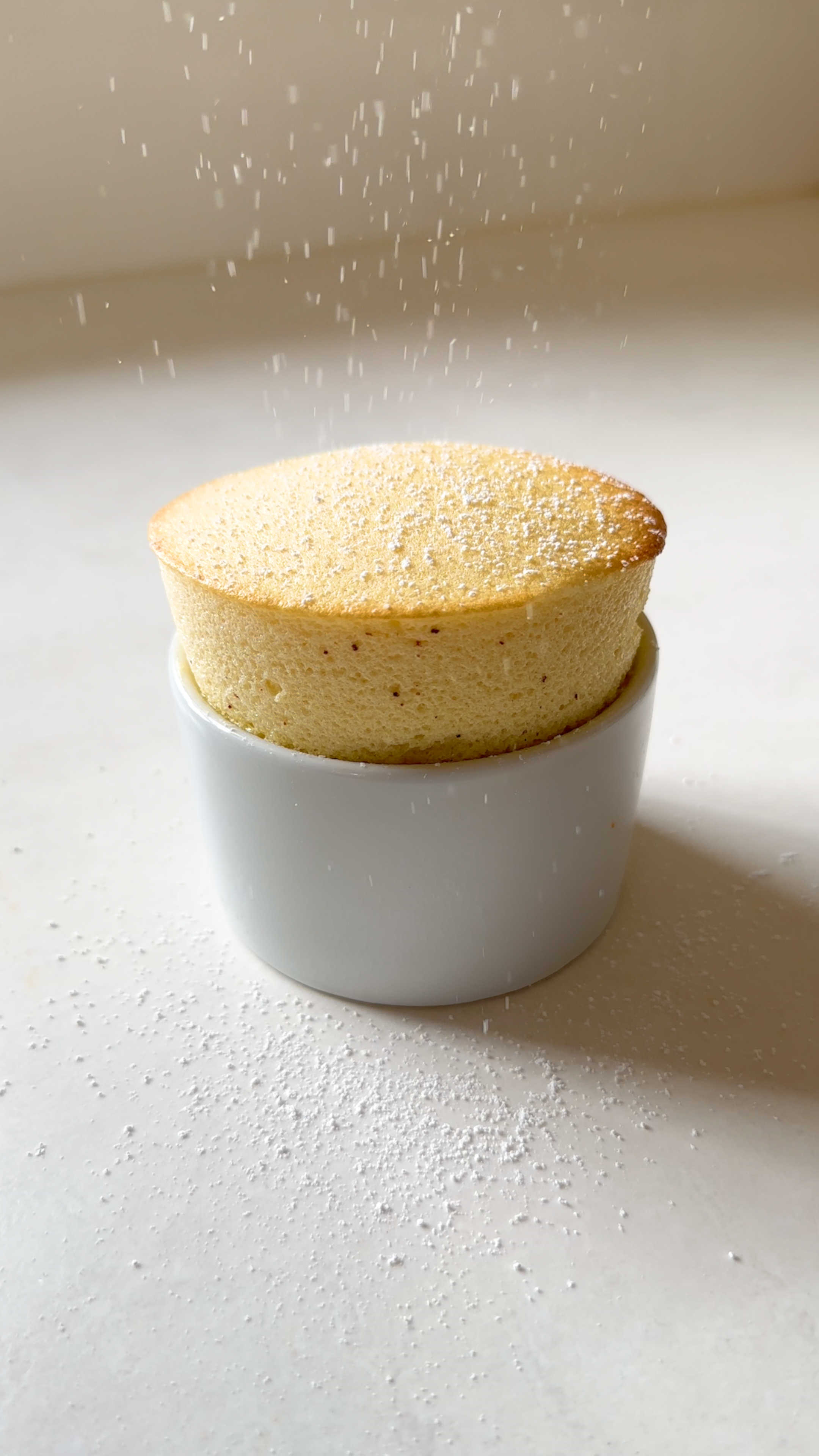 Passion fruit soufflé being dusted with icing sugar