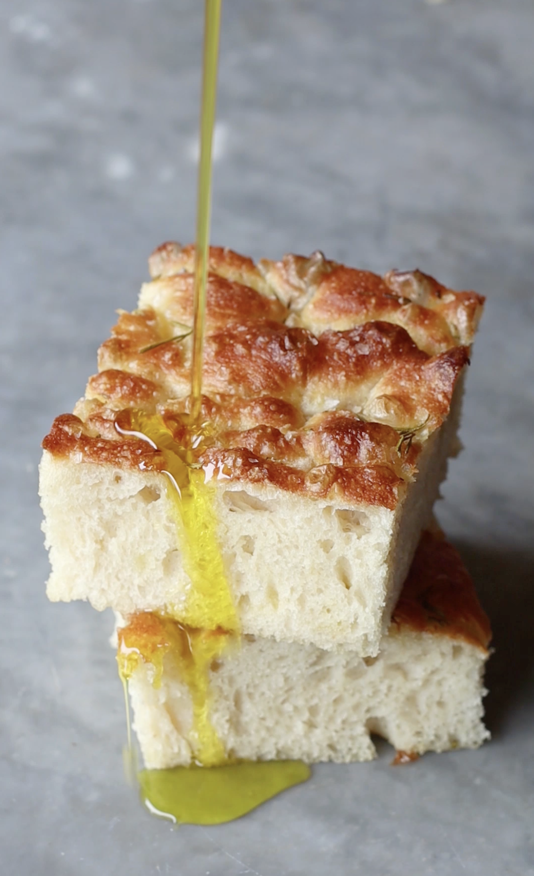 Two slices of overnight focaccia with drizzled olive oil