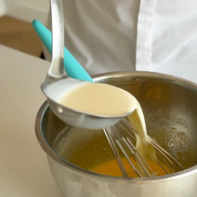 Add hot cream over egg mixture