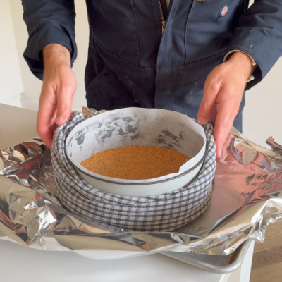 Line the cheesecake tin with wet tea towels